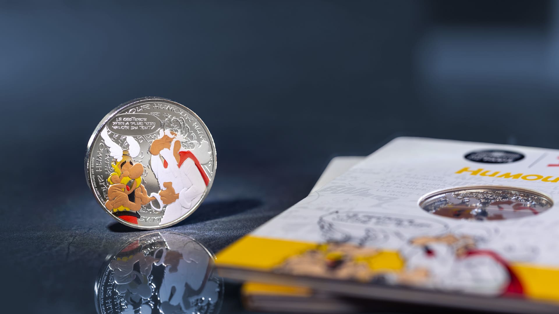 Eine Asterix Münze steht neben seiner Blisterverpackung Eine Asterix Münze steht neben seiner Blisterverpackung