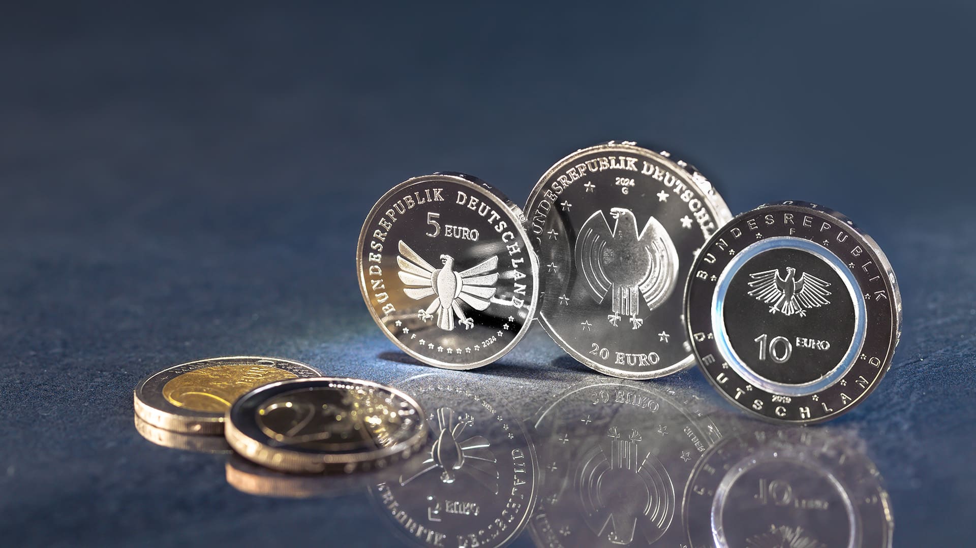Deutsche Euro-Münzen stehen vor blau-grauen Hintergrund Deutsche Euro-Münzen stehen vor blau-grauen Hintergrund