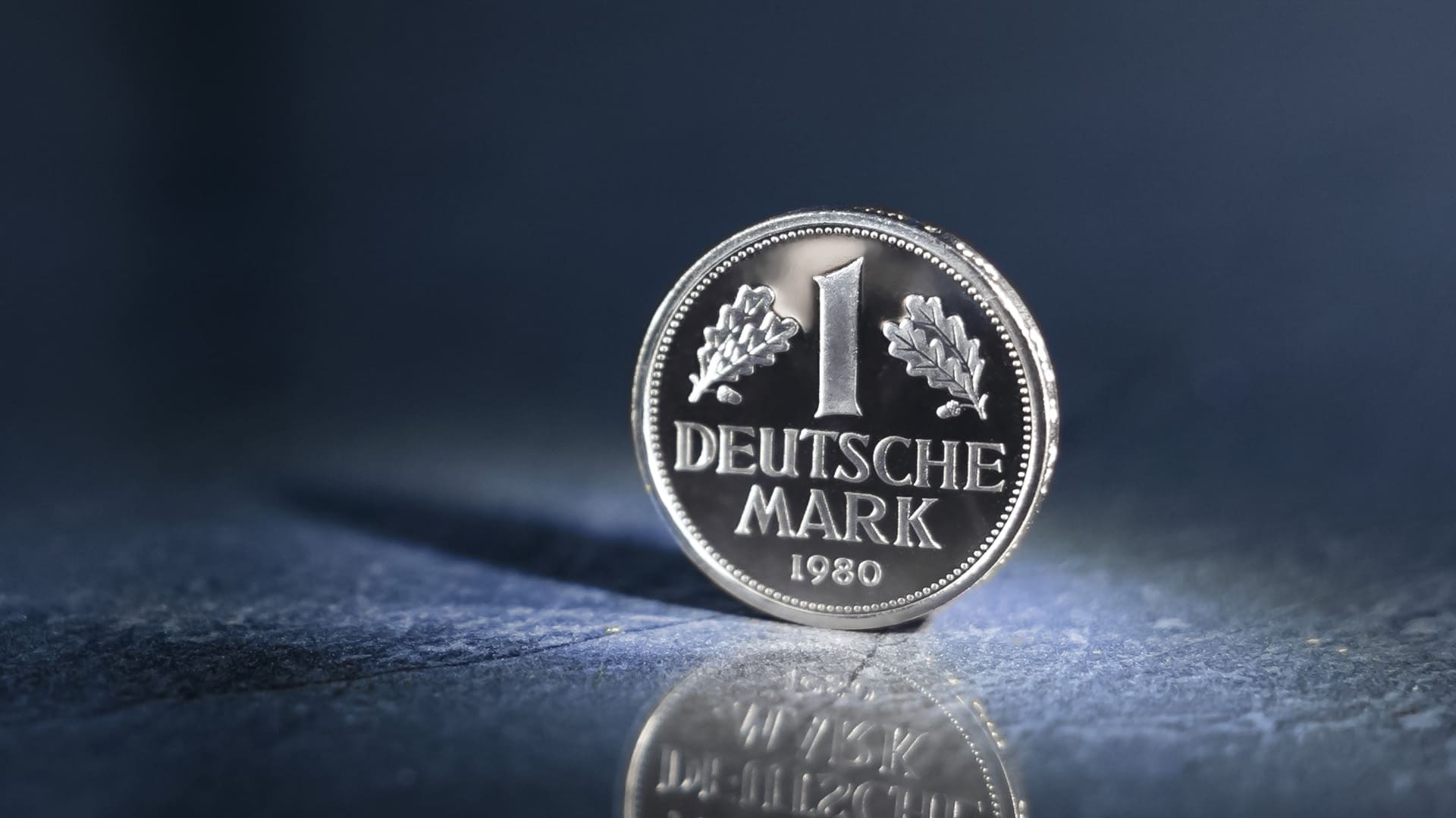 Nahaufnahme von der Vorderseite einer 1-DM-Kursmünze aus dem Jahr 1980 auf einem dunklen Hintergrund Nahaufnahme von der Vorderseite einer 1-DM-Kursmünze aus dem Jahr 1980 auf einem dunklen Hintergrund