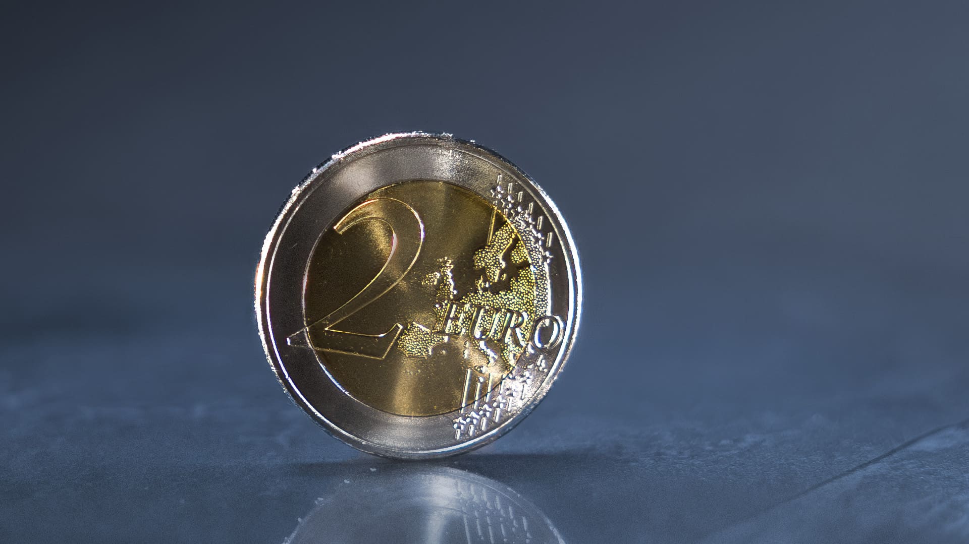 Nahaufnahme von der Vorderseite einer 2-Euro-Münze auf einem dunklen Hintergrund Nahaufnahme von der Vorderseite einer 2-Euro-Münze auf einem dunklen Hintergrund