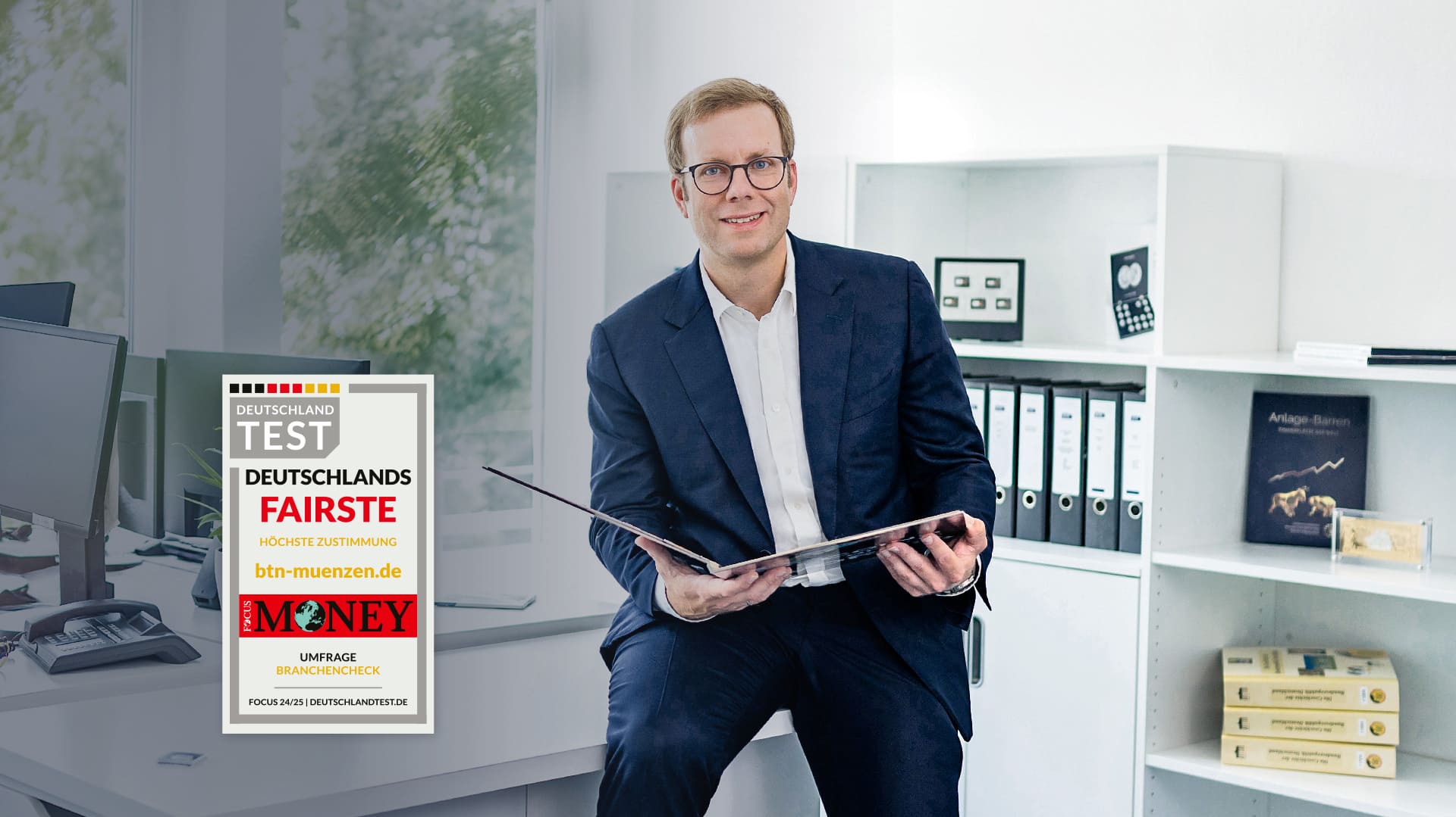 Geschäftsführer hält offenes Album in den Händen während er sich in einer Bürogegend befindet. Das Siegel "Faires Unternehmen" ist auf der linken Seite abgebildet. Geschäftsführer hält offenes Album in den Händen während er sich in einer Bürogegend befindet. Das Siegel "Faires Unternehmen" ist auf der linken Seite abgebildet.