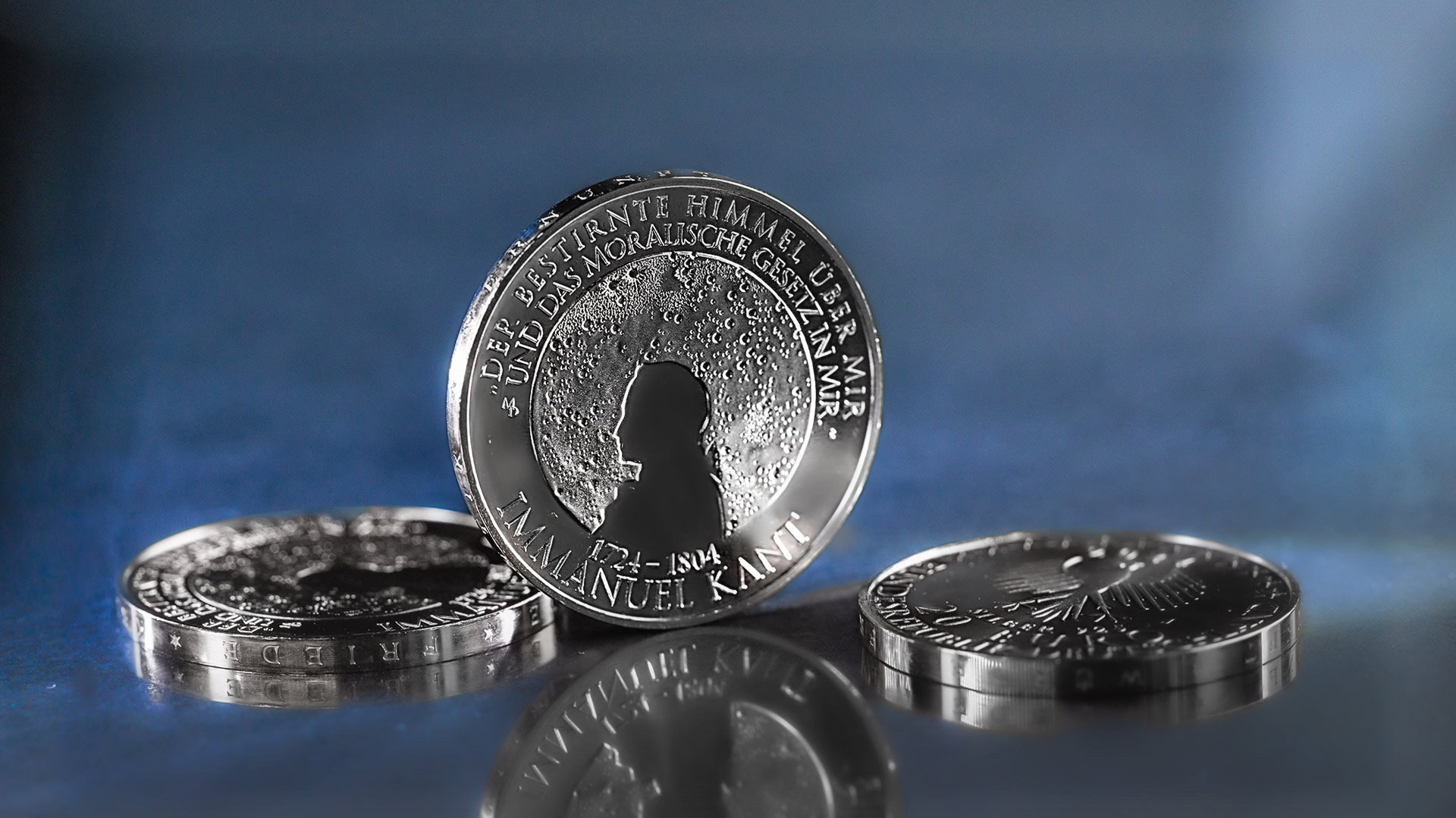 Die 20-Euro-Münze Immanuel Kant steht vor blau-grauen Hintergrund Die 20-Euro-Münze Immanuel Kant steht vor blau-grauen Hintergrund
