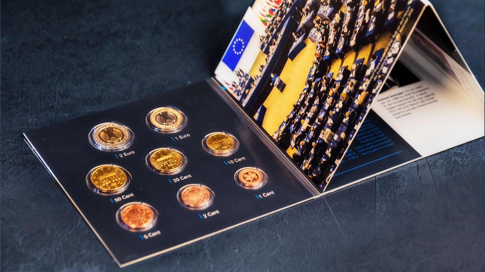 Euro-Kursmünzensatz in Blisterverpackung vor blau-grauen Hintergrund Euro-Kursmünzensatz in Blisterverpackung vor blau-grauen Hintergrund