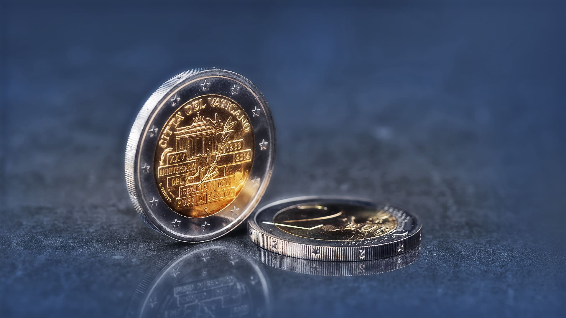Nahaufnahme einer 2-Euro-Münze aus dem Vatikan von 2014 zum Fall der Berliner Mauer auf einem dunklen Hintergrund Nahaufnahme einer 2-Euro-Münze aus dem Vatikan von 2014 zum Fall der Berliner Mauer auf einem dunklen Hintergrund