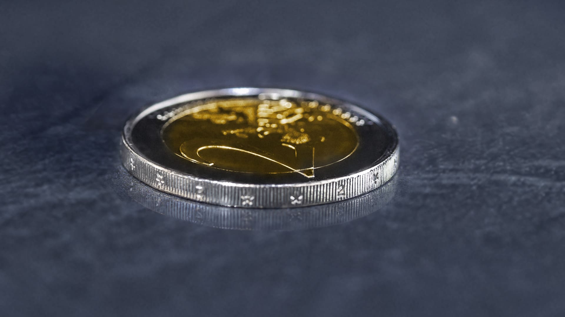 2-Euro-Münze liegt auf blau-grauen Hintergrund 2-Euro-Münze liegt auf blau-grauen Hintergrund
