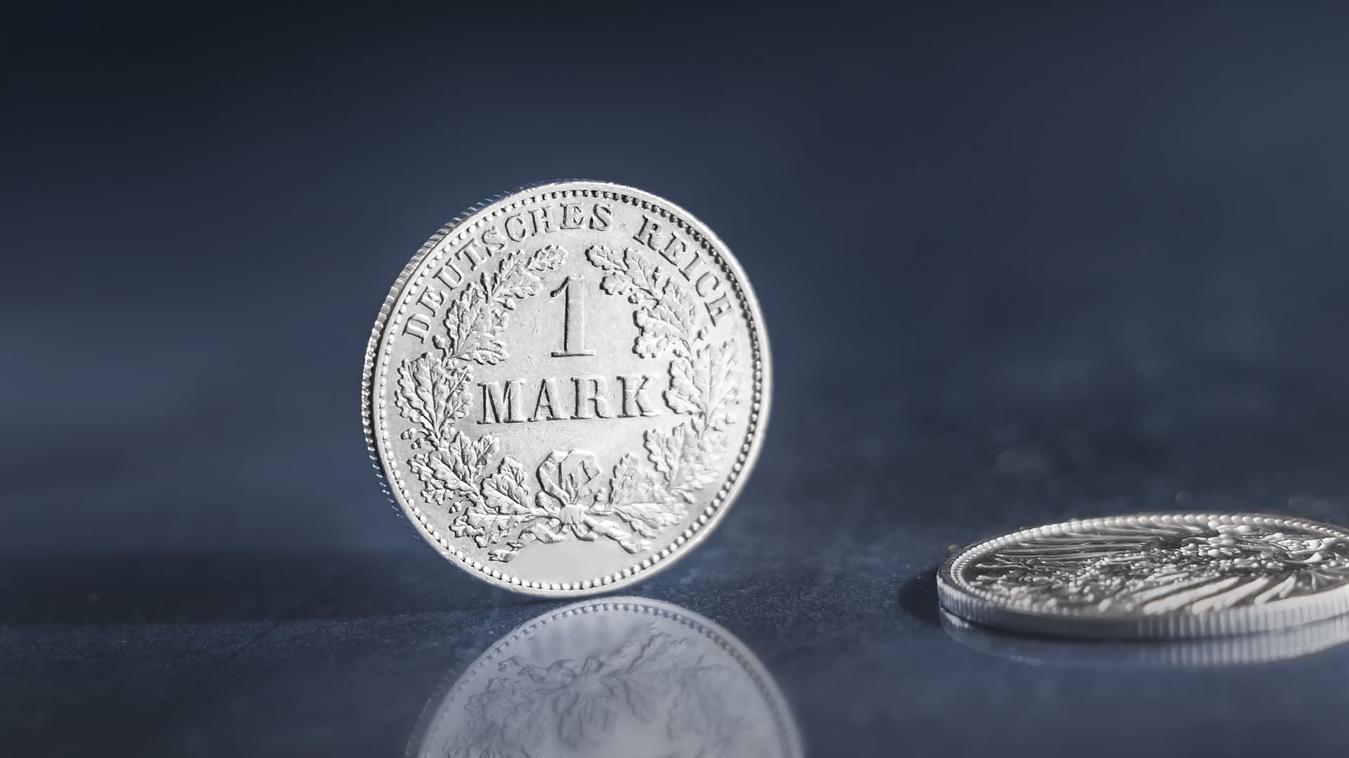 Eine 1-Mark-Münze steht vor blau-grauen Hintergrund Eine 1-Mark-Münze steht vor blau-grauen Hintergrund