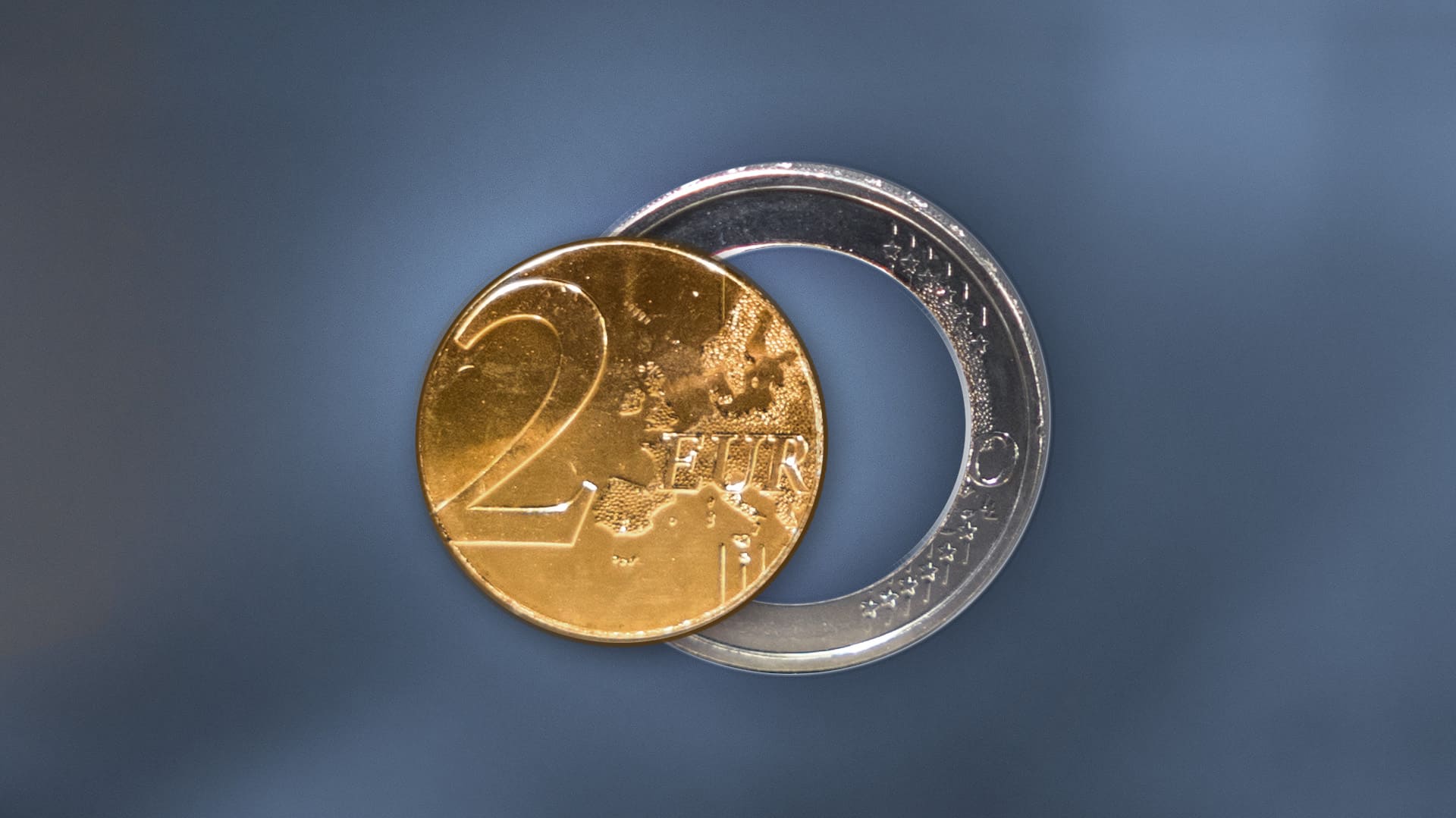 Münzring und Münzkern einer 2-Euro-Münze auf einem dunklen Hintergrund Münzring und Münzkern einer 2-Euro-Münze auf einem dunklen Hintergrund