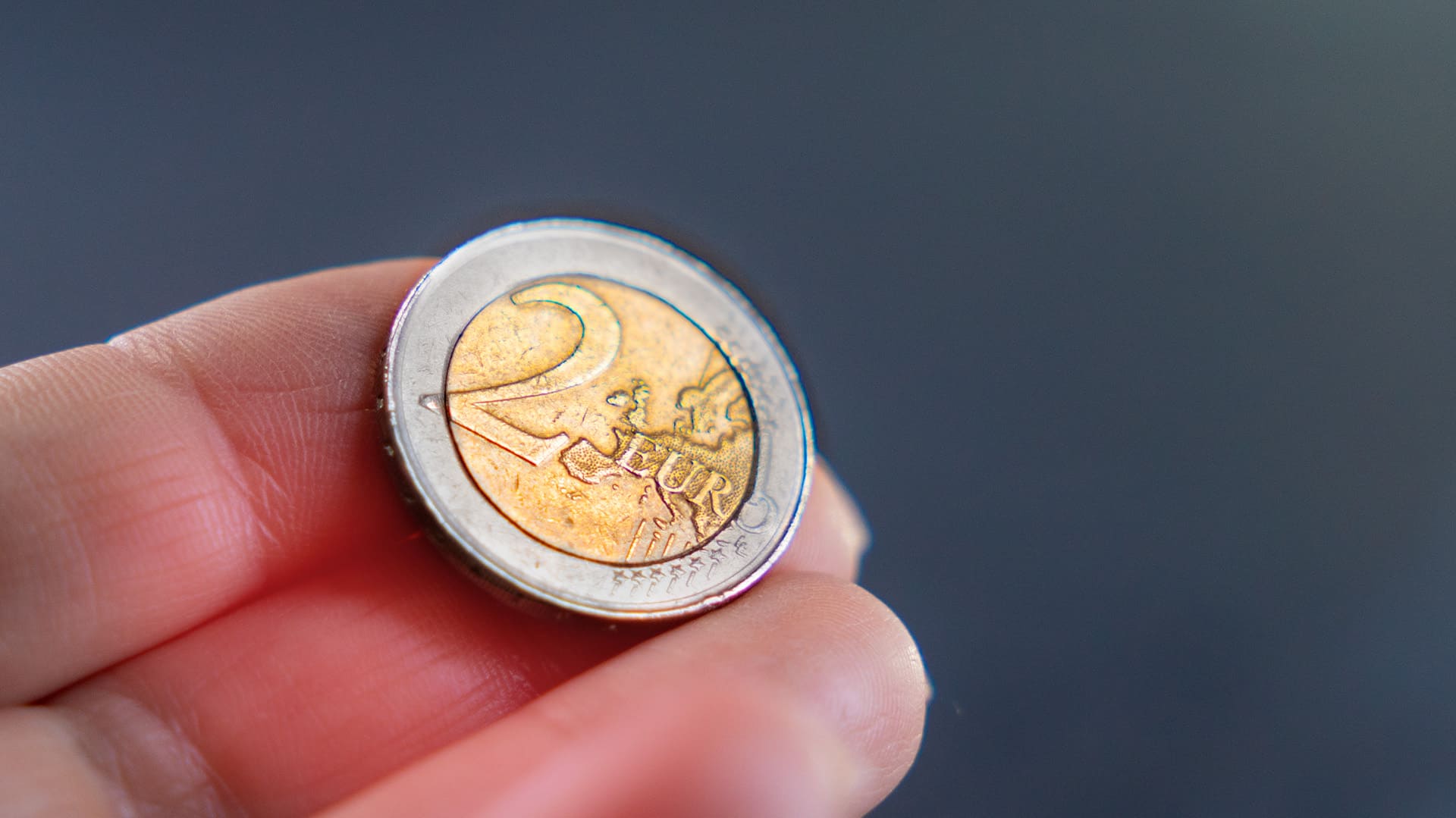 Nahaufnahme von der Vorderseite einer 2-Euro-Münze in einer Hand Nahaufnahme von der Vorderseite einer 2-Euro-Münze in einer Hand